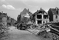 Das Foto von Anfang Juli 1941 zeigt das verwüstete Gebiet um die Maximilianstraße. Mehrere Männer tragen den Schutt ab und beladen Fahrzeuge damit.