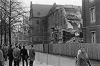 Mehrere Personen beobachten den Abriss des alten Regierungsgebäudes aus dem 19. Jahrhundert am Domplatz.