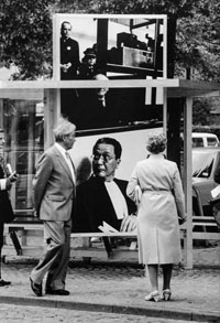 Ein älterer Mannn und eine ältere Frau betrachten ein künstlerisch gestaltete Bushaltestelle