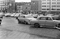 Auf dem Bild ist die dicht befahrene Bahnhofsstraße zu sehen. Die Häuserreihe auf der gegenüberliegenden Straßenseite ist noch nicht geschlossen.