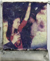Foto eines Polaroids, das eine tanzende junge Frau zeigt, mit Knicken und Trittspuren