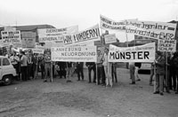 Mehrere junge Männer mit Spruchbändern und Plakaten