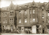 Schwarz-weiß Fotografie des Wohn- und Geschäftshauses Raesfeldstraße 4 mit der Kolonialwarenhandlung Henke im Erdgeschoß