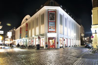 Die beleuchtete Außenfassade des Museums bei Nacht.