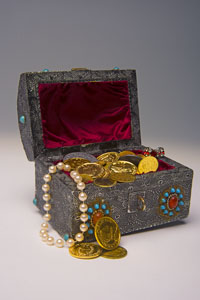 Schatz 200px Eine Schatztruhe, aus der Goldstücke und Goldketten herausluken