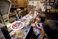 Kinder stehen im historischen Laden Henke im Stadtmuseum.