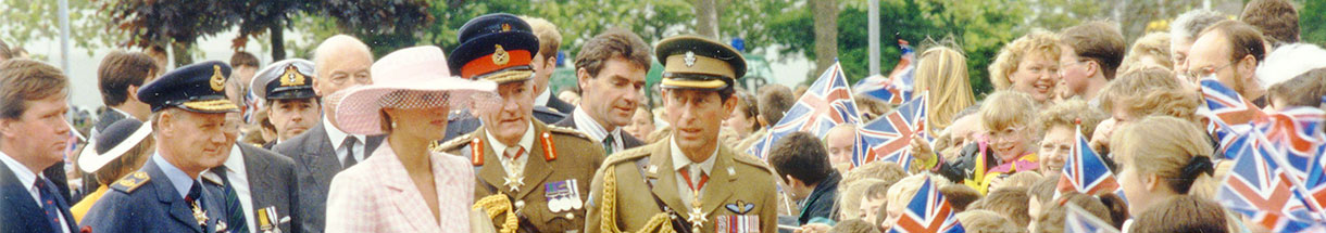 Prince Charles und Princess Diana gehen an vielen Menschen entlang, die britische Fahnen aus Papier schwenken.