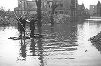Foto zeigt zwei Personen auf einem Behelfsfloß in der überschwemmten Scharnhorststraße