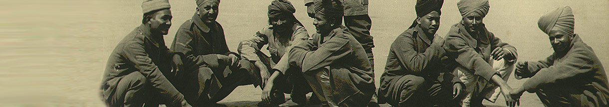 Dunkelhäutige Männer mit turbanähnliche Kopfbedeckungen hocken am Boden