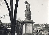 Foto zeigt ein Denkmal in Form einer Frauengestalt, die den Kopf senkt. Die Frau stellt die Germania dar und befindet sich auf einem Steinsockel.