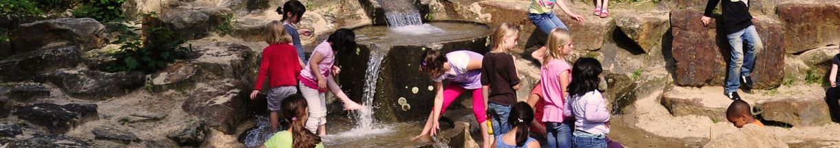 Kinder spielen am Wasserfall