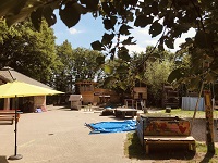 Das Außengelände: Holzbauten, Sand- und Wiesenfläche