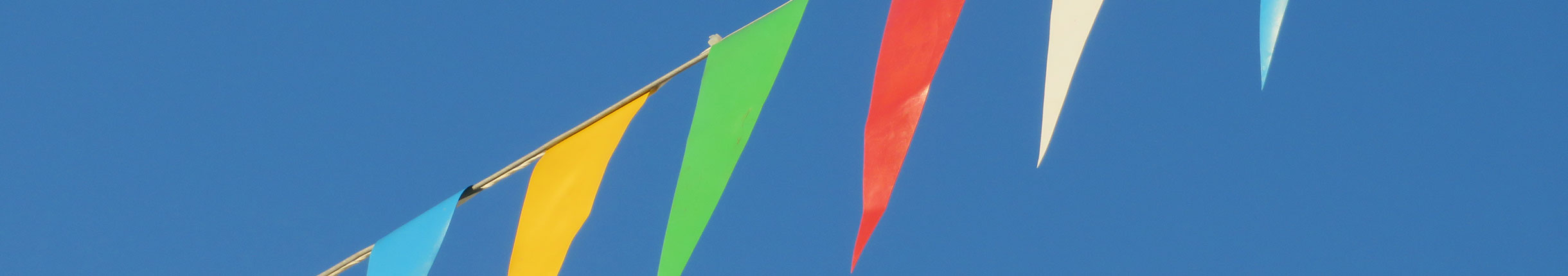 Bunte Fähnchen vor blauem Himmel