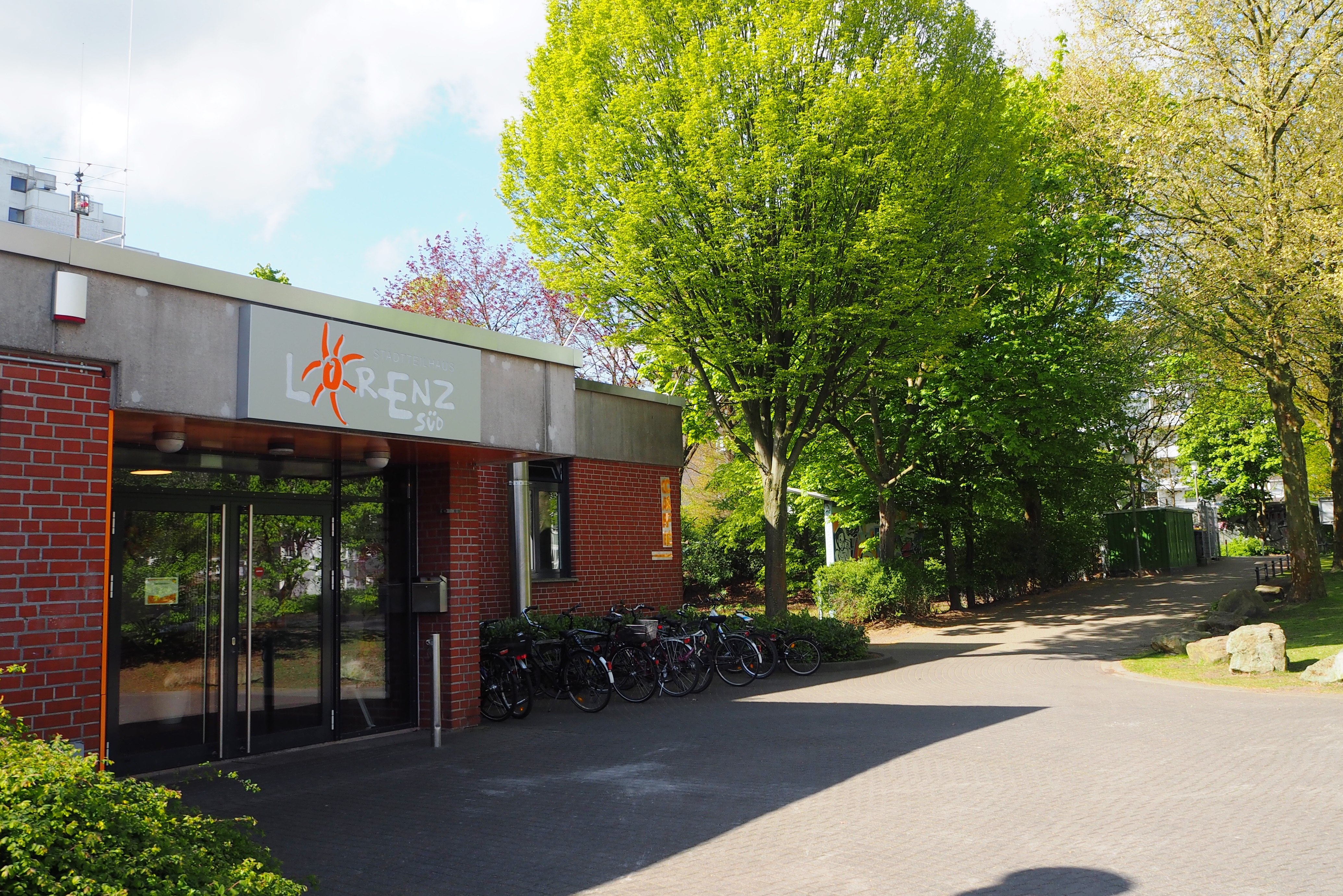 Außenansicht vom Eingang des Lorenz-Süd; im Hintergrund Baume mit grünen Blättern