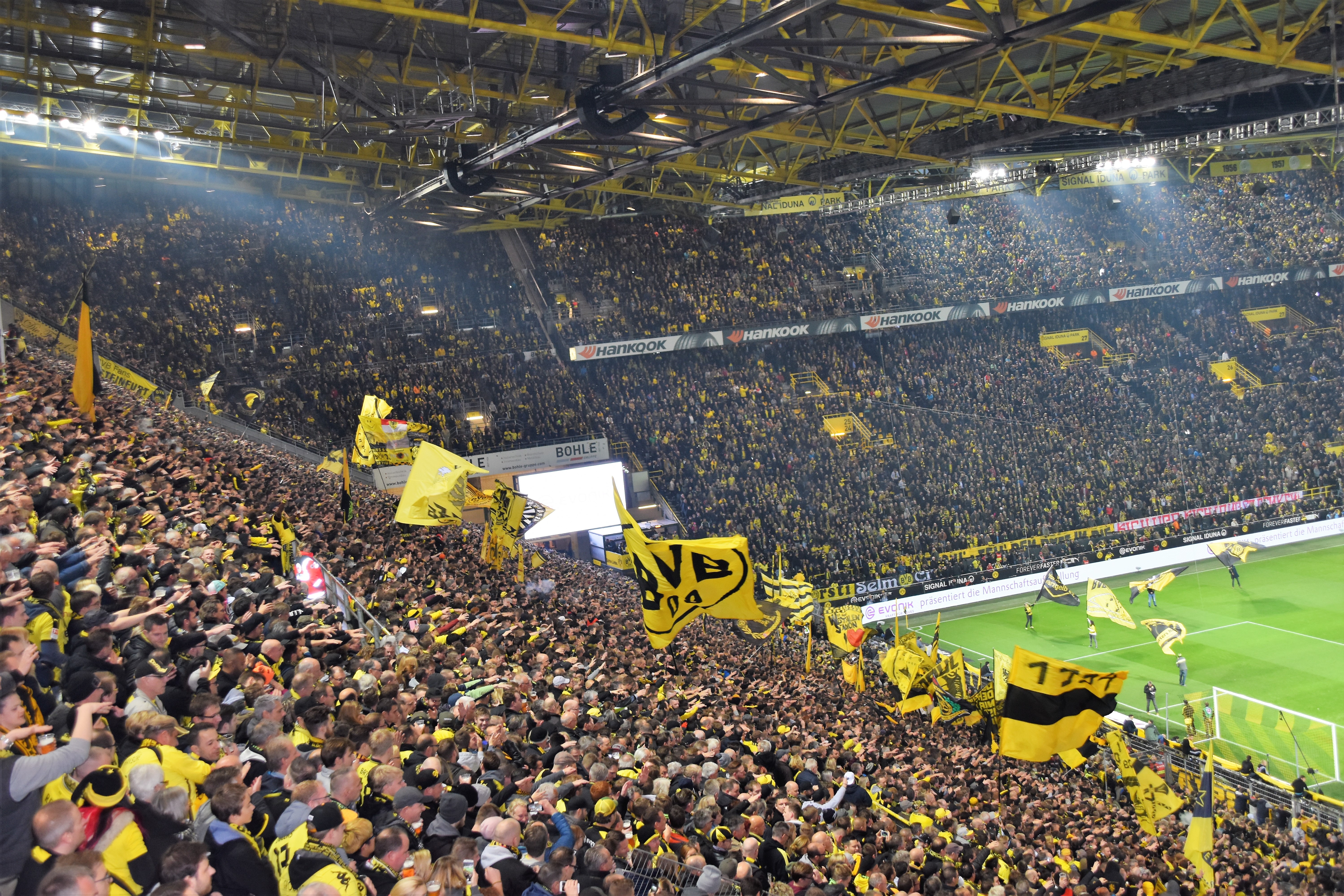 blick über die Tribüne auf die Ecke des Spielfelds in einem Fußballstadion voll mit Fans.