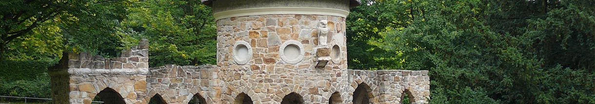 Gemauerter Turm mit einer steinernen Eule