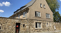 Verputztes Gebäude mit Natursteinsockel