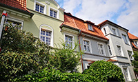 Hohe Häuser mit pastellfarbenen Fassaden und mehrteiligen Fenstern