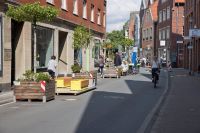 Das Foto zeigt die Hörsterstraße während des Verkehrsversuches: Ein Teilstück war für Autos gesperrt und so konnte für Zufußgehende und Radfahrende ein Raum mit Aufenthaltsqualität geschaffen werden