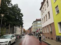 Zu sehen ist eien rote Fahrradstraße auf der auf der einen Seite Autos parken und auf der restlichen Fläche der Fahrbahn Radfahrende unterwegs sind (Foto: Stadt Münster)