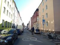 Foto der Schillerstraße: Zu sehen sind beidseitig parkende Autos auf der Fahrbahn und ein Radfahrender