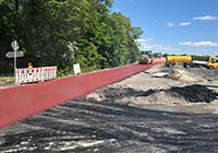 Rot asphaltierte Fahrbahn mit Baufahrzeugen