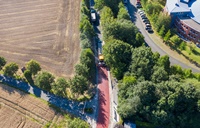 Blick auf eine rote Fahrbahn zwischen Feldern
