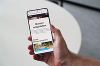 Abgebildet ist ein Handy, worauf die Beteiligungsplattform "Münster mitgestalten" abgebildet ist