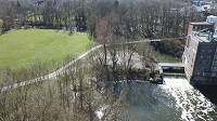 Auf der rechten Seite des Bildes ist das Werse-Wehr abgebildet. Links daneben befindet sich eine größere Rasenfläche und ein Fuß- und Radweg. Auf dieser Seite soll ein naturnaher Wasserlauf entstehen.