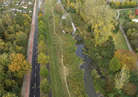 Blick links auf die Straße, Geh- und Radweg mit angrenzendem Flusslauf.