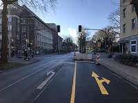 Kreuzung mit Ampelanlagen und provisorische Markierungen auf der Straße.