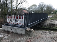 Blick auf die neue Brücke - mit Baken abgesperrt; rechts darunter Verlauf des Baches.