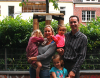 Baumpatenfamilie an der Promenade Eine Familie mit drei kleinen Kindern an einem jungen Baum.