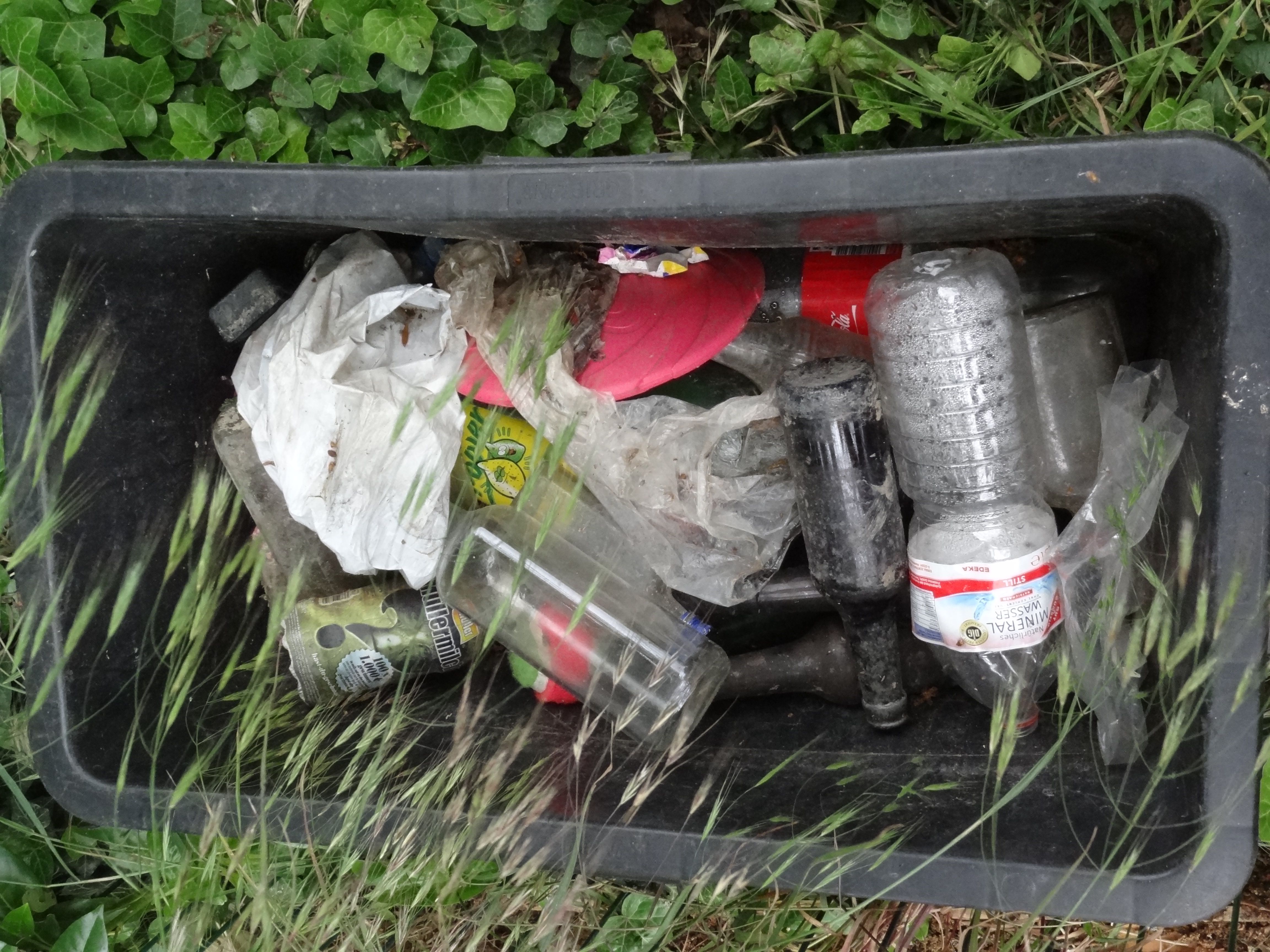 Ein Sammelbehälter gefüllt mit Plastikmüll wie alten Plastikflaschen und Plastktüten.
