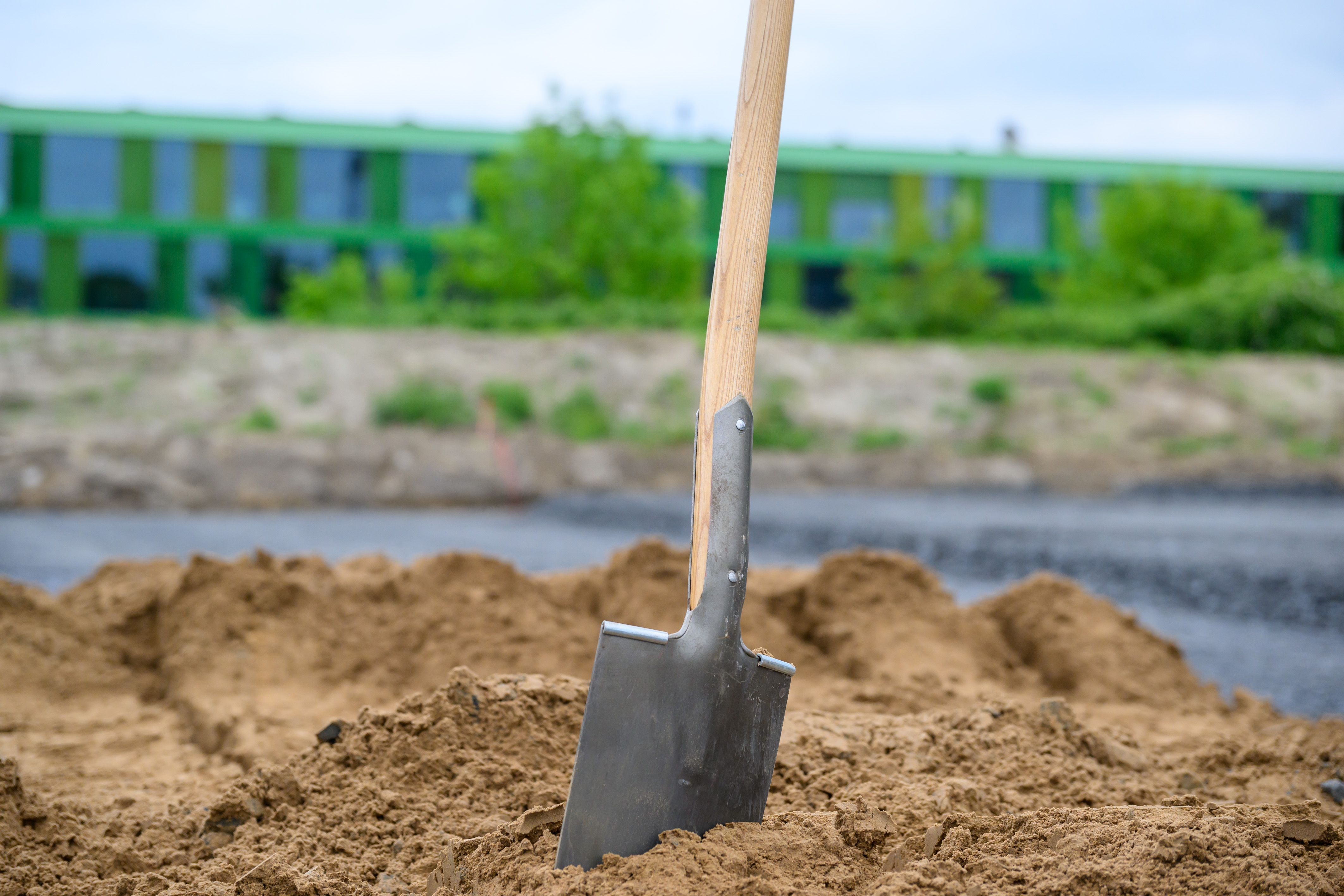 Ein Spaten steckt im Bausand - Detailaufnahme