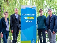 Von links nach rechts: Isabel Scherer (KLENKO), Daniel Westerholt (BuGG), Dr. Christian Wolf und Veit Muddemann (KLENKO) beim Gründach-Forum. In der Mitte steht ein Banner mit der Aufschrift "Gemeinsam für unser Klima".