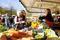 Das Bild eines Marktstandes mit Kunden.