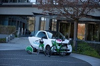 Zu sehen ist ein E-Auto, davor steht ein E-Roller und ein E-Bike.