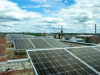 Dach mit Photovoltaik. Im Hintergrund die Innenstadt Münsters.