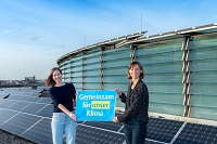 Jana Lange (l.) und Ramona Leusch von der städtischen Koordinierungsstelle für Klima und Energie auf einem Dach mit Photovoltaikanlagen