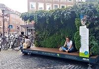 Im "Mobilen Grünen Zimmer" sitzen Passantinen und Passanten und telefonieren oder ruhen sich aus.