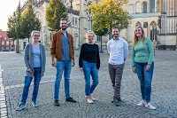 KlimaTrainerinnen und -Trainer der ersten Stunde: Sibylle Radefeld, Carsten Dietzel, Lena Dücker, Christian Kubina und Jana Bauckmann (von links nach rechts). Die ersten fünf KlimaTrainerinnen und -Trainer stehen gemeinsam auf dem Domplatz und lächeln in die Kamera: Sibylle Radefeld, Carsten Dietzel, Lena Dücker, Christian Kubina und Jana Bauckmann (von links nach rechts).