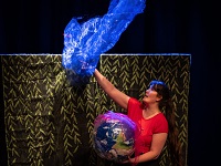 Schauspielerin des Theaterpädagoischen Zentrums mit Weltkugel in der Hand.