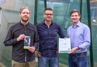 Gruppenbild während einer Beratungssituation: Julian Schütte (Stadt Münster), Ingo Niggemann (Niggemann Glas & Spiegel) und Energieberater Marcel Stueer (Bode Planungsgesellschaft für Energieeffizienz) stehen vor großen Fenstergläsern.