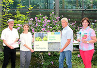 Gruppenfoto: Vier Personen halten Broschüren und ein Banner mit der Aufschrift 'Lebendige Gärten statt Schottergärten'.