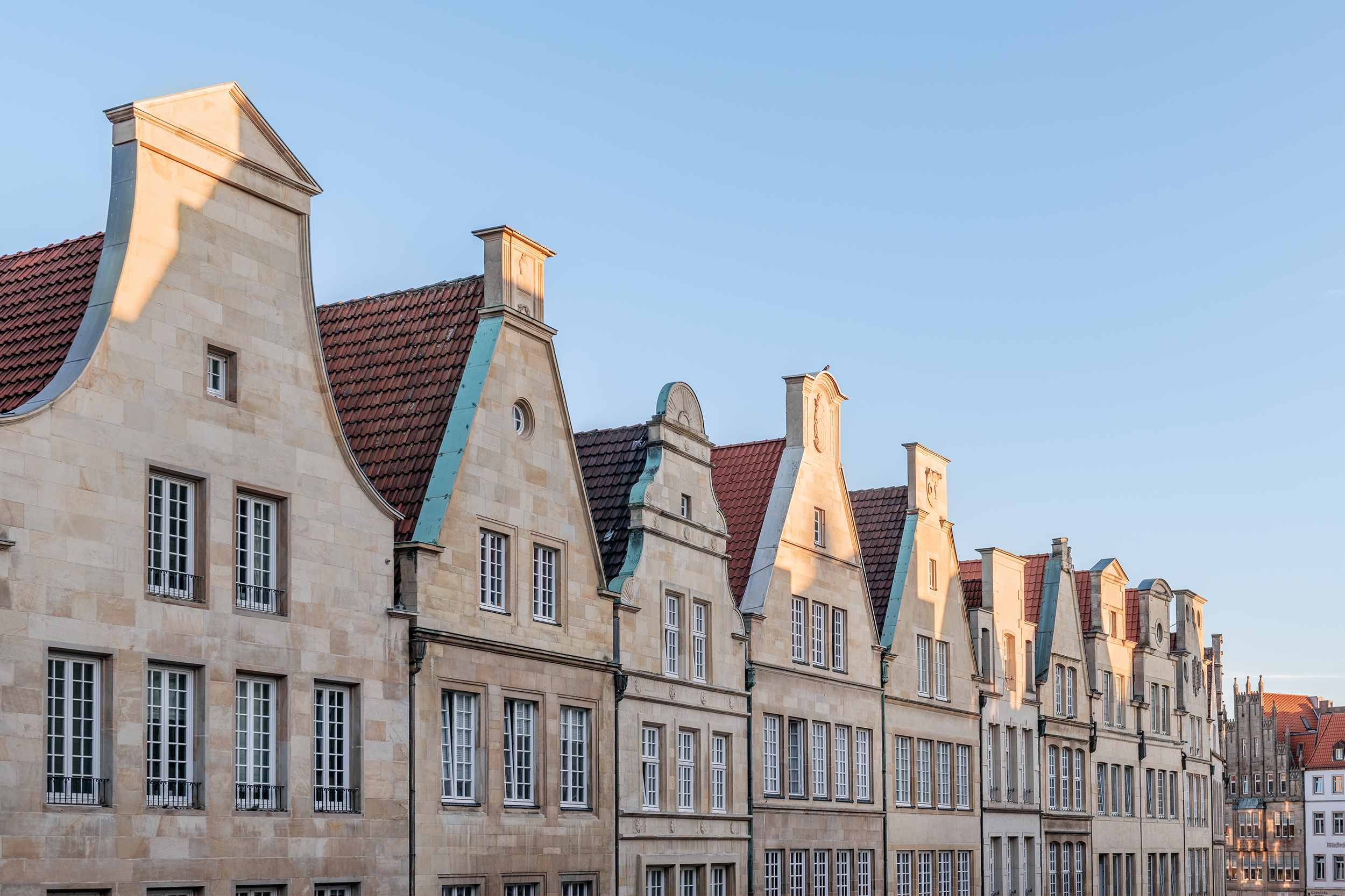 Die Giebelhäuser am Prinzipalmarkt in Münster vor blauem Himmel.