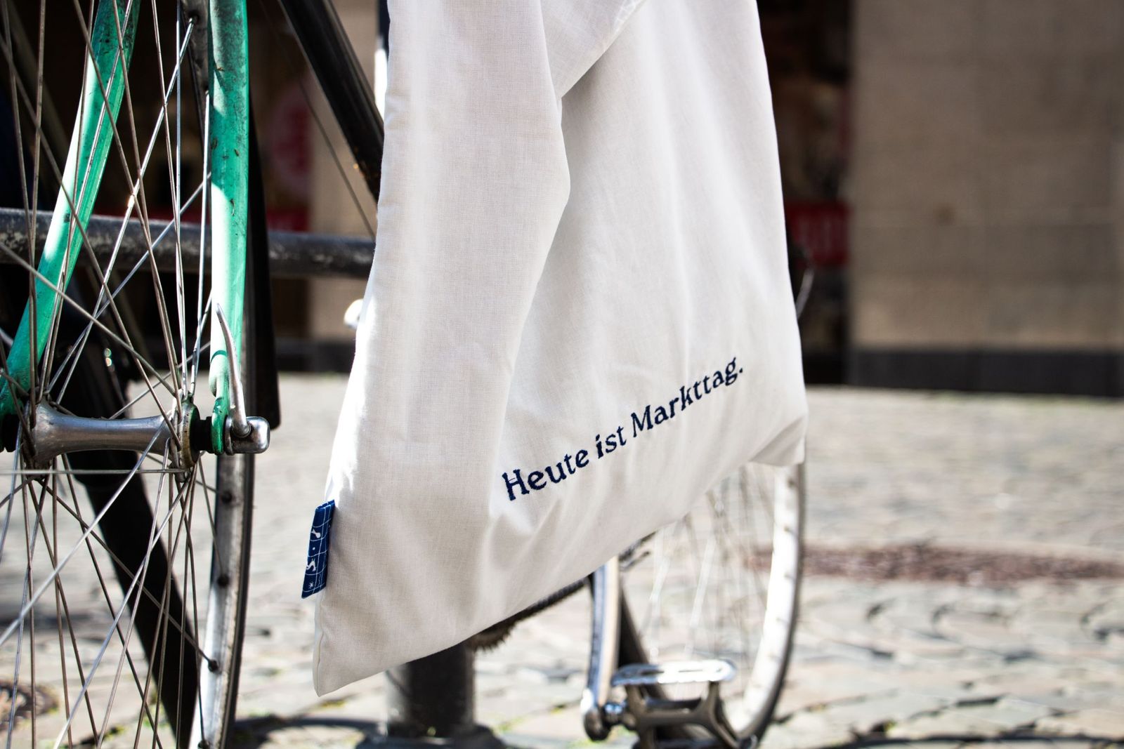 Ein Stoffbeutel mit der Aufschrift "Heute ist Markttag" hängt an einem Fahrrad.