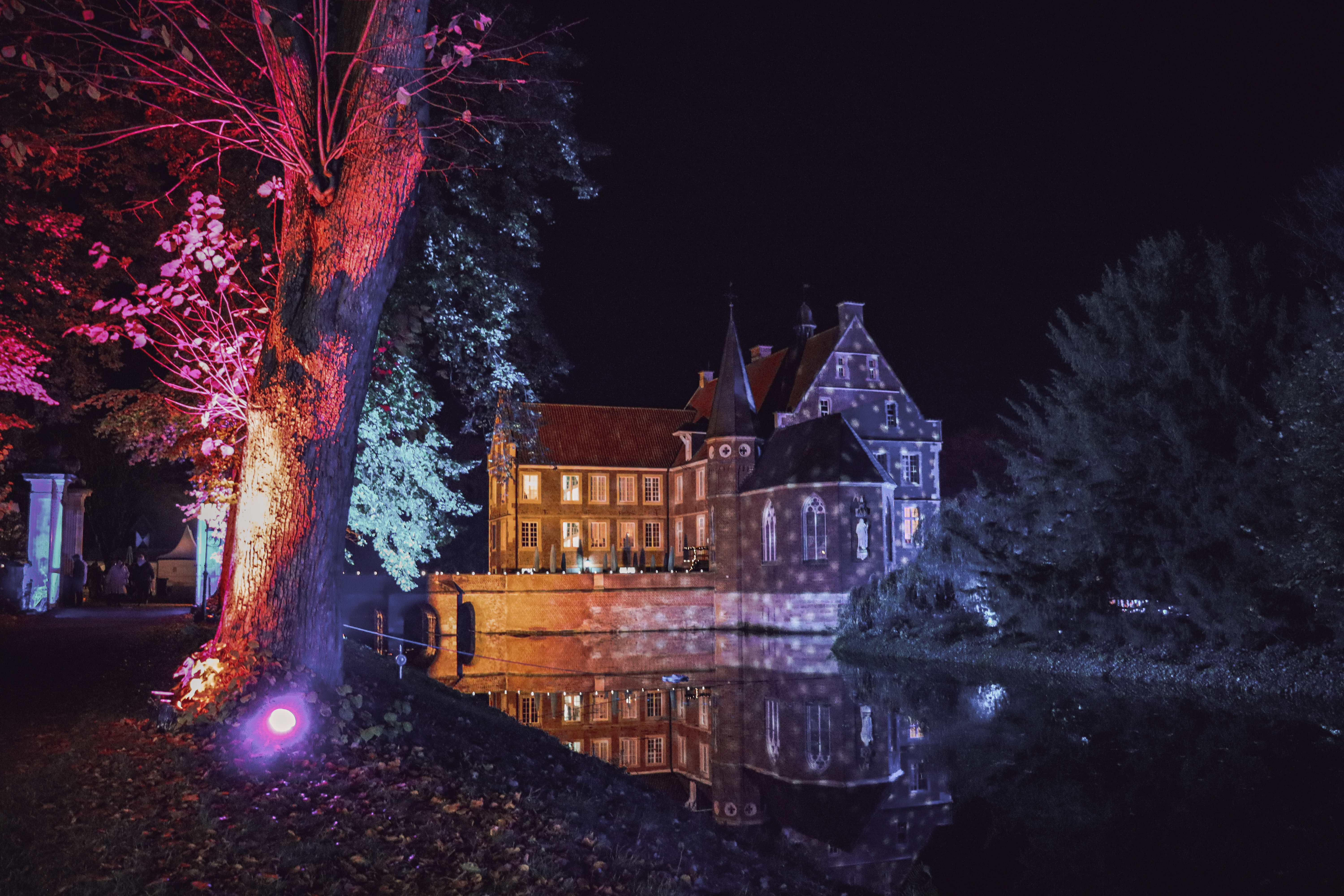 Die Burg Hülshoff in Havixbeck bunt beleuchtet in der Adventszeit.
