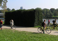 Bicyclists in front of the sculpture by Rosemarie Trockel