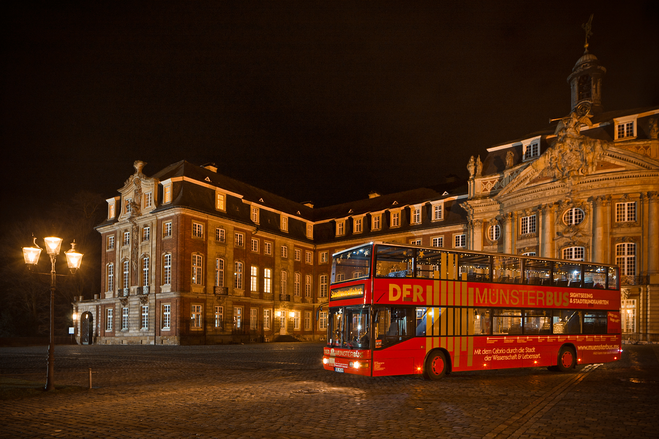 Der Münster-Bus vor dem beleuchteten Schloss